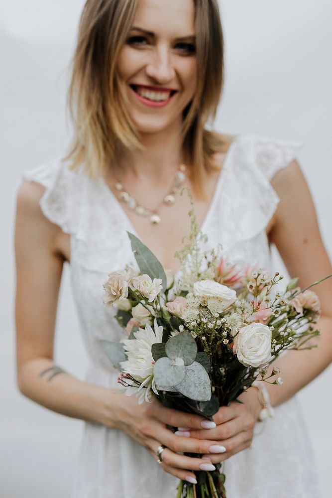 Cheerful bride holding a flower bouquet