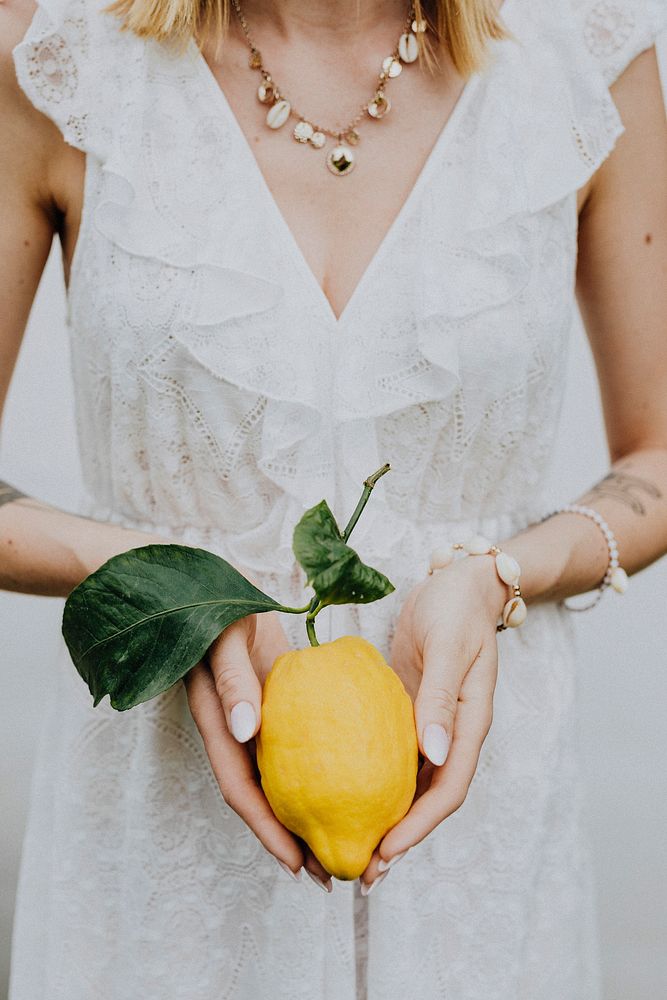 Woman holding a fresh lemon