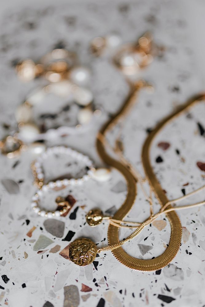 Aerial view of gold jewelries on a white marble background