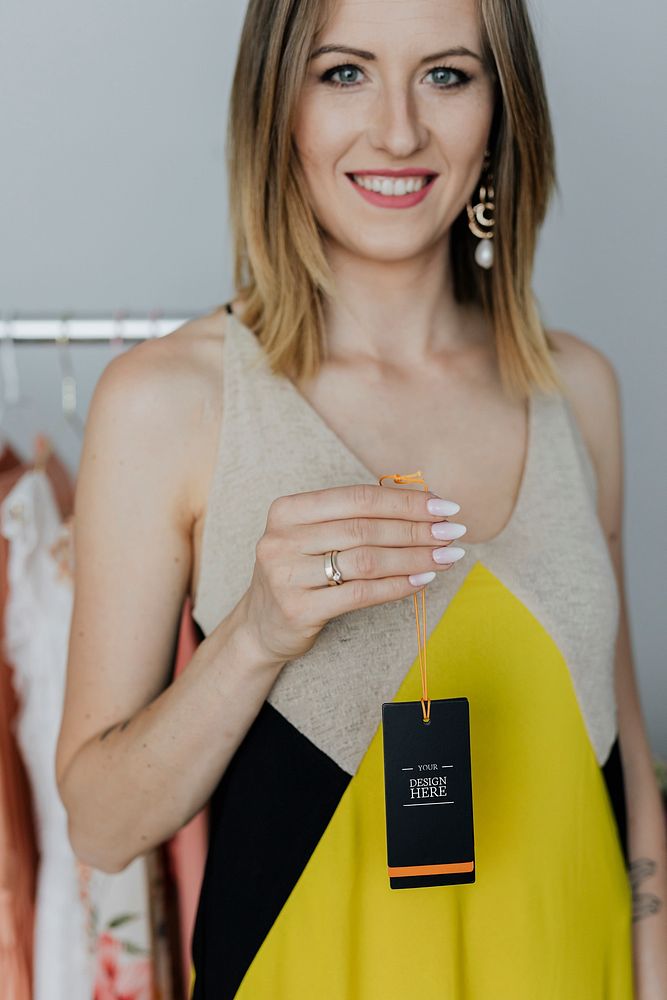 Woman in a yellow dress holding a black tag mockup