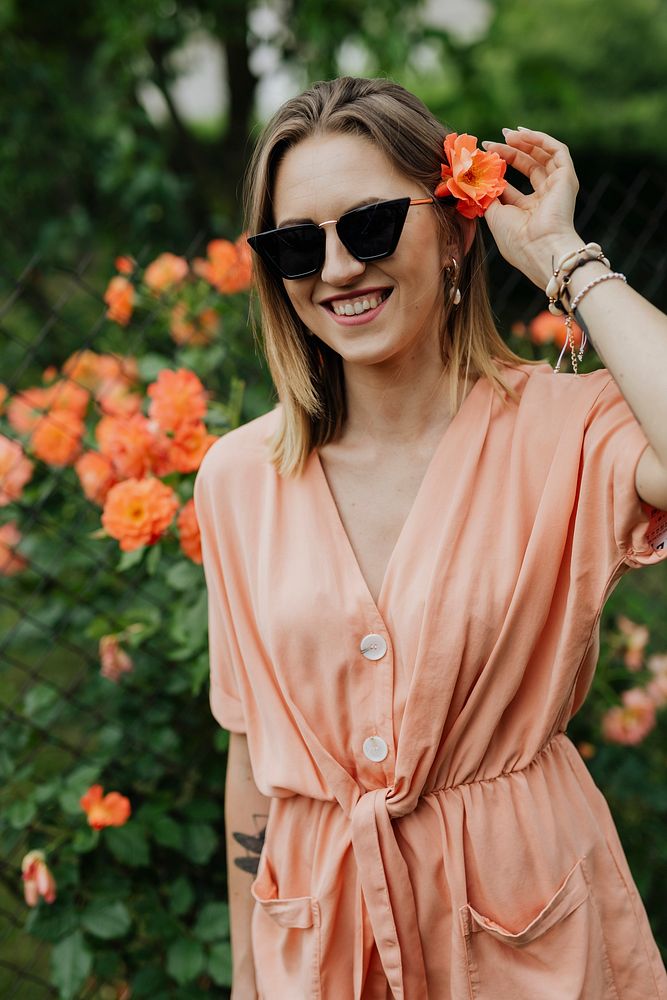 Cheerful woman with an orange rose