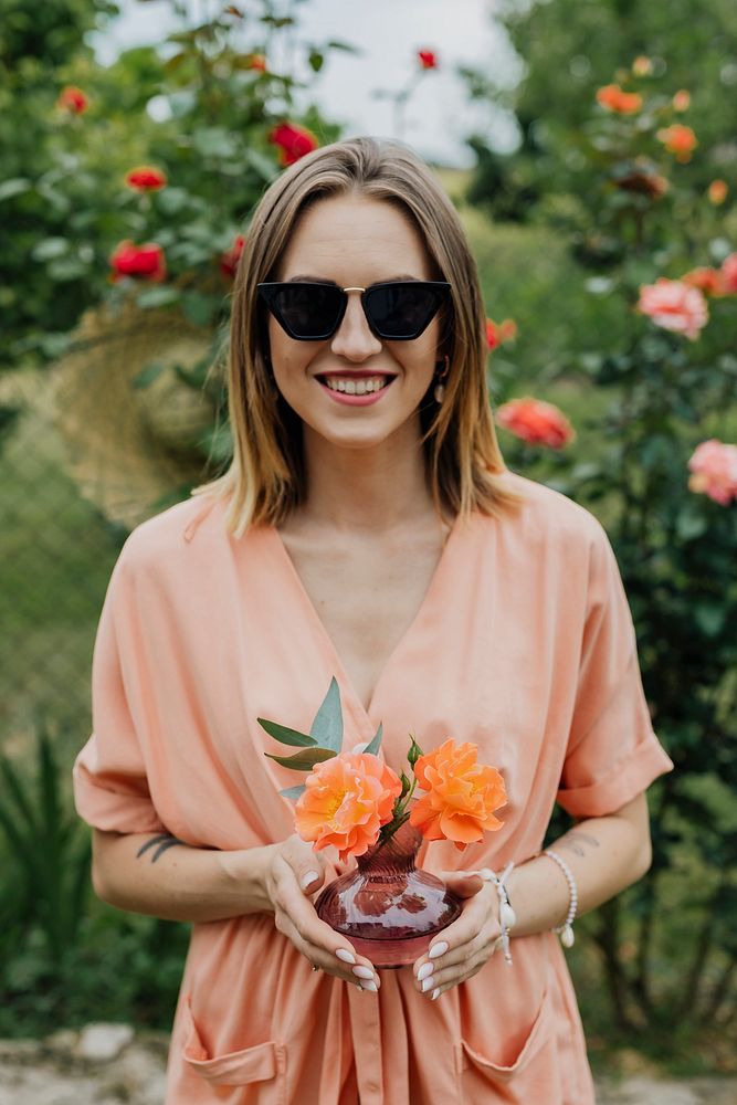 Woman holding a vase of orange roses