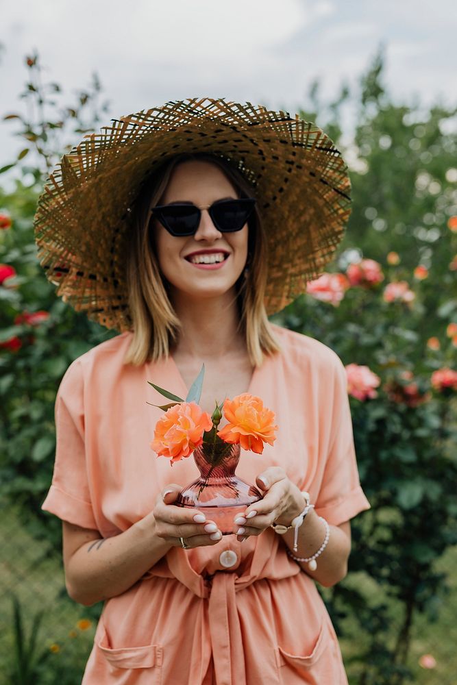 Woman holding a vase of orange roses