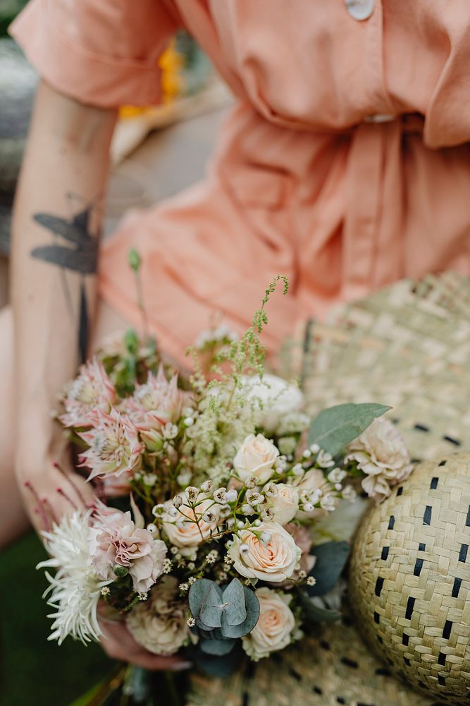 Woman in an orange jumpsuit with a bouquet of flowers