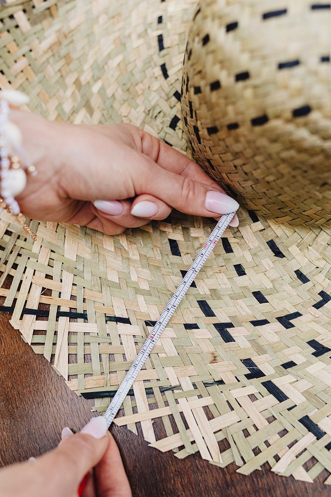 Woman measuring a woven hat