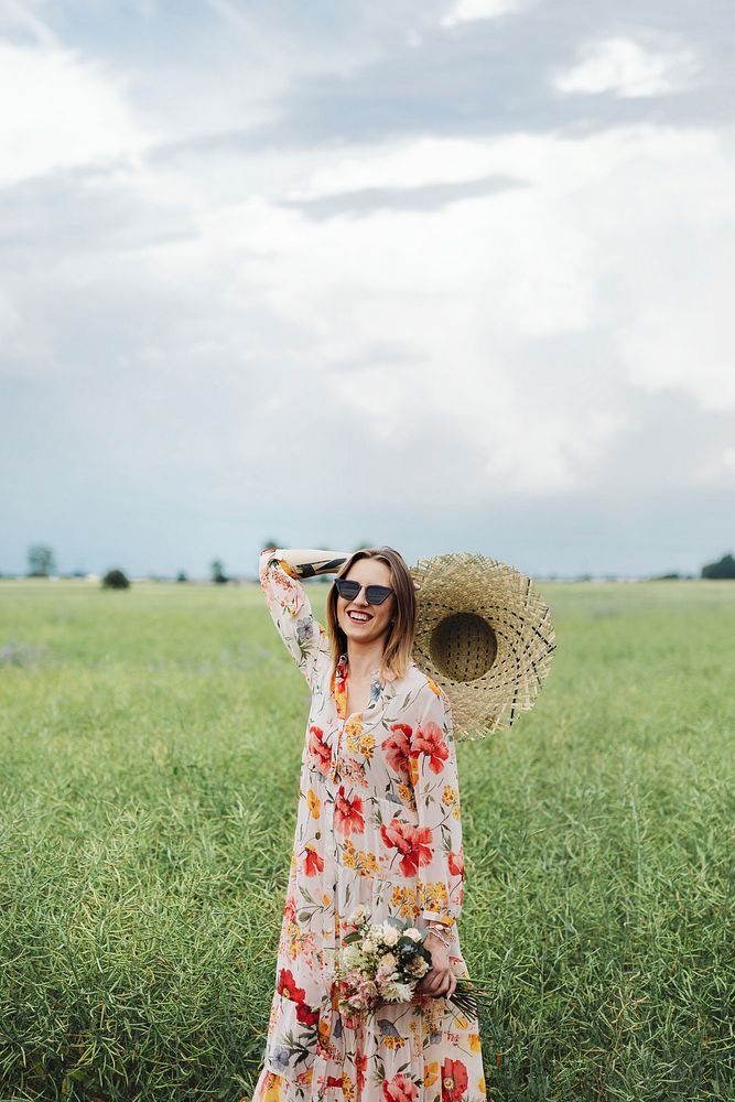 Cheerful woman in a floral dress in a field