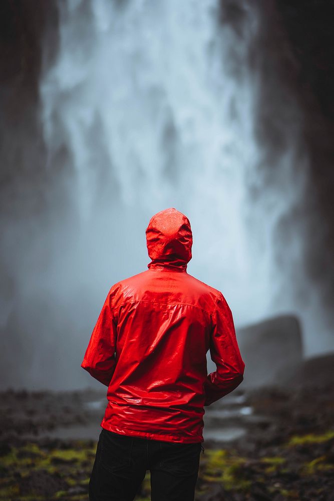 Man in a red windbreaker at the Haifoss waterfall, Iceland