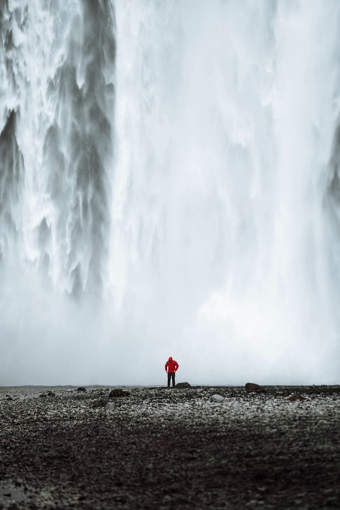 Man standing in front of Sk&oacute;gafoss waterfall, Iceland