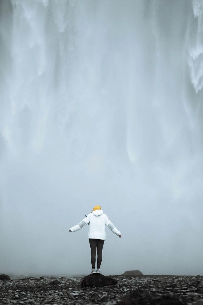 Woman standing in front of  Sk&oacute;gafoss waterfall, Iceland