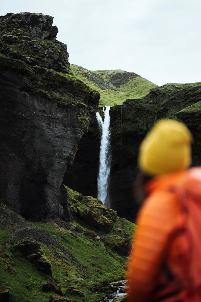 Female hiker with a view of Kvernufoss waterfall in South Iceland