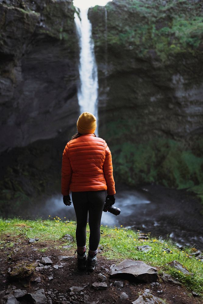 Female hiker with a view of Kvernufoss waterfall in South Iceland