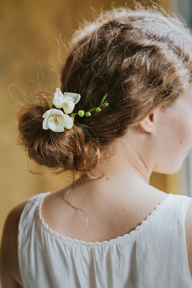 Girl with white freesia flowers in her hair