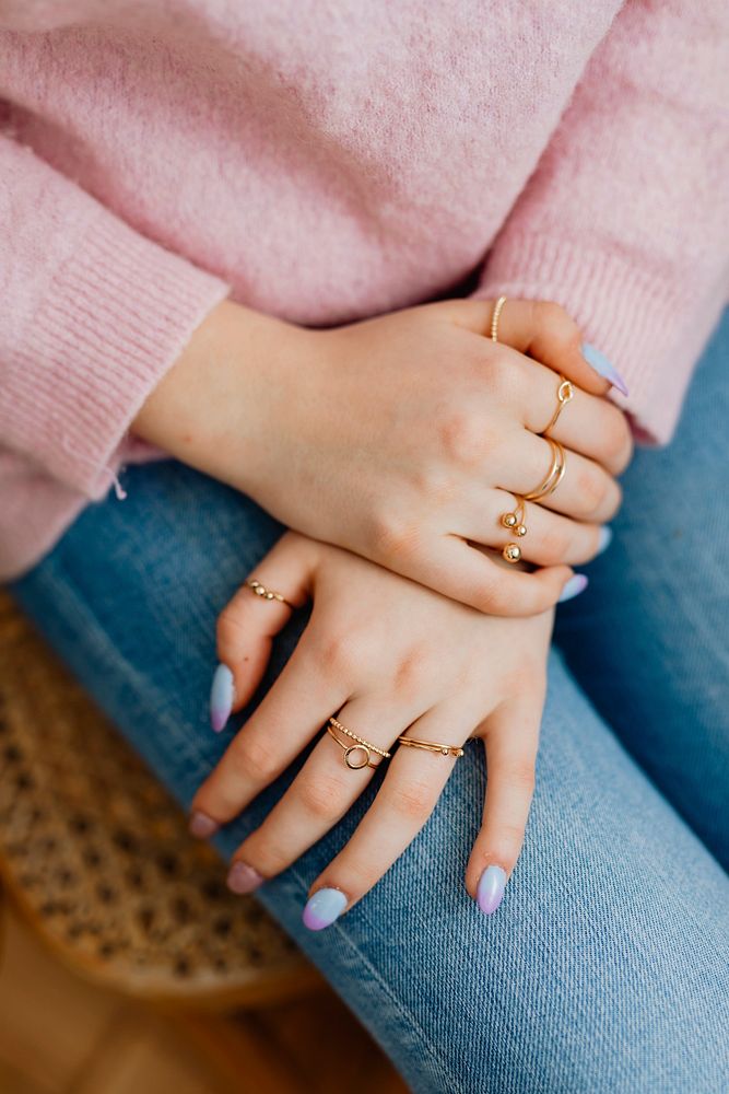 Closeup of painted nails and rings on her fingers