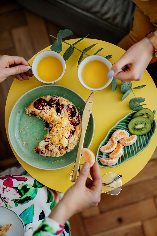 Women having tea with plum crumble pie