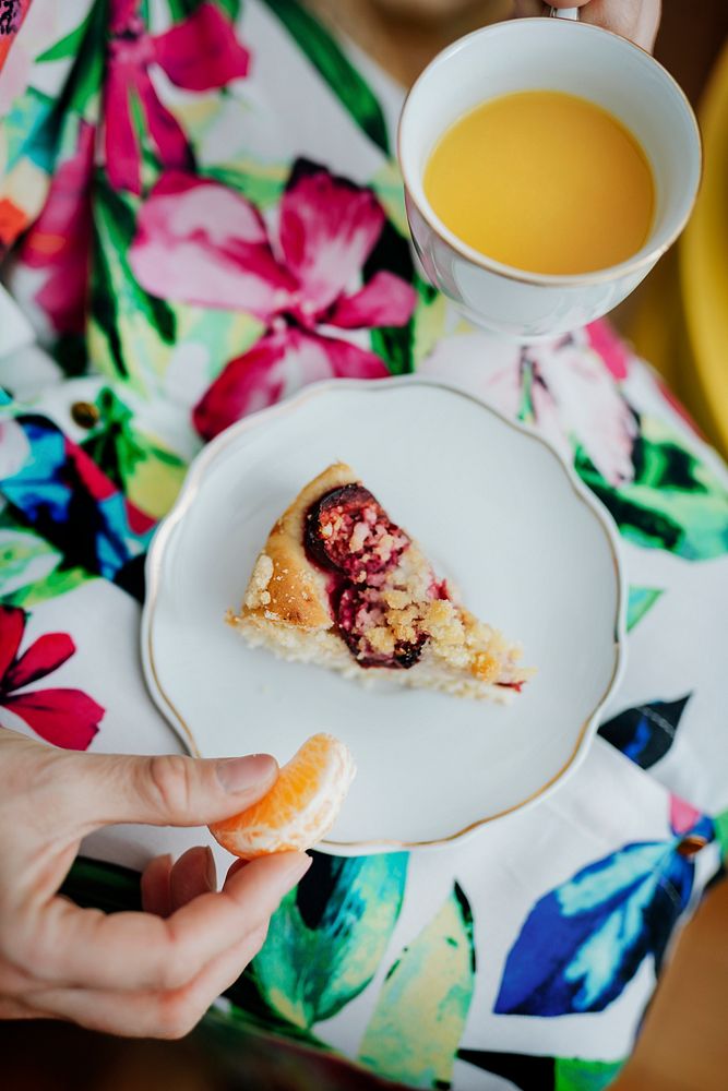 Woman eating orange with plum crumble pie