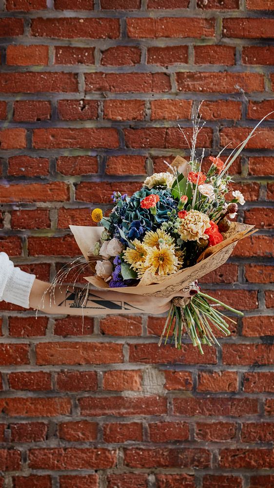 Bouquet of colorful flowers in front of brick wall