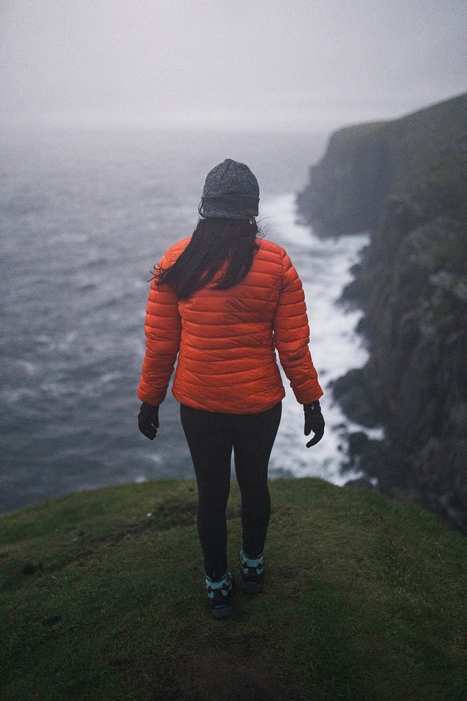 Rear view of woman standing near the cliff at Isle of Skye, Scotland