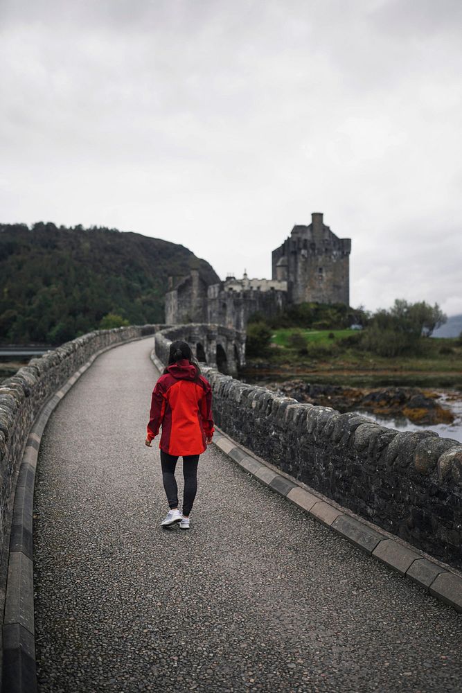 Female traveler on a bridge at Eilean Donan Castle, Scotland