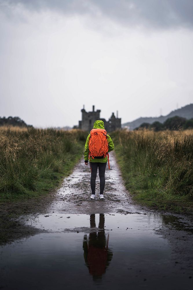 Rear view of a woman in front of Kilchurn Castle, Scotland