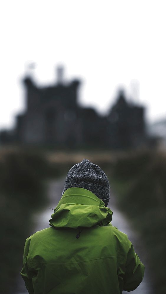 Rear view of a woman in front of Kilchurn Castle, Scotland mobile phone wallpaper