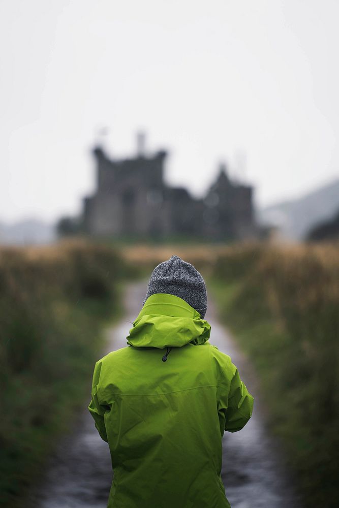 Rear view of a woman in front of Kilchurn Castle, Scotland