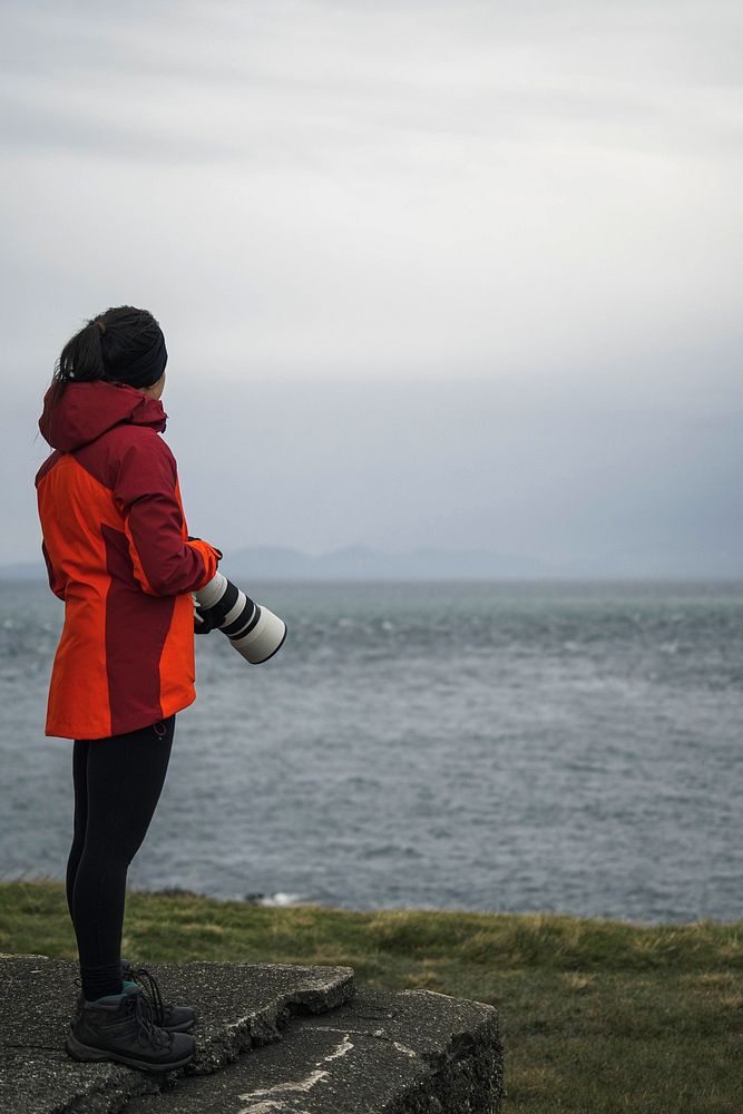 Female photographer at Vaternish Lighthouse on Isle of Skye, Scotland