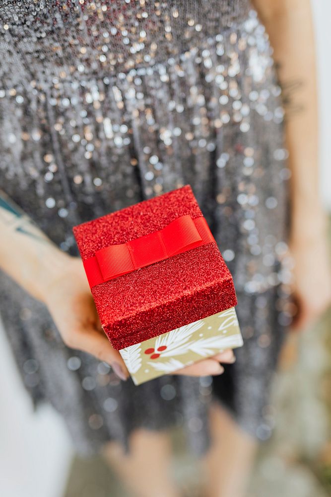 Woman in a silver dress holding gift boxes