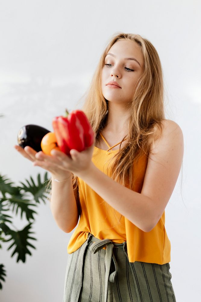 Blond woman holding fruit and vegetables