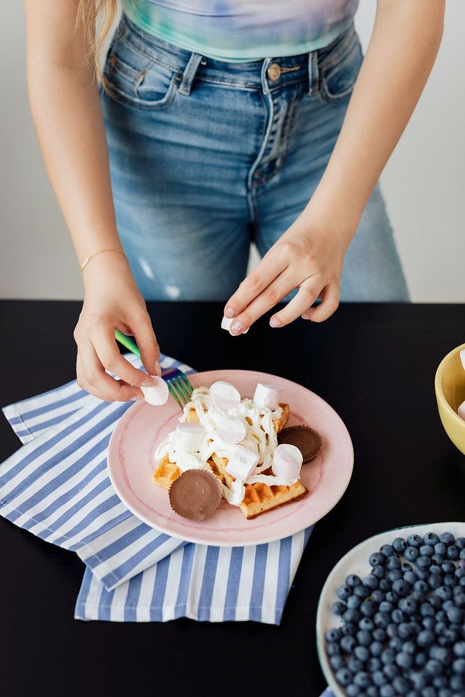 Woman decorating her waffles with marshmallows
