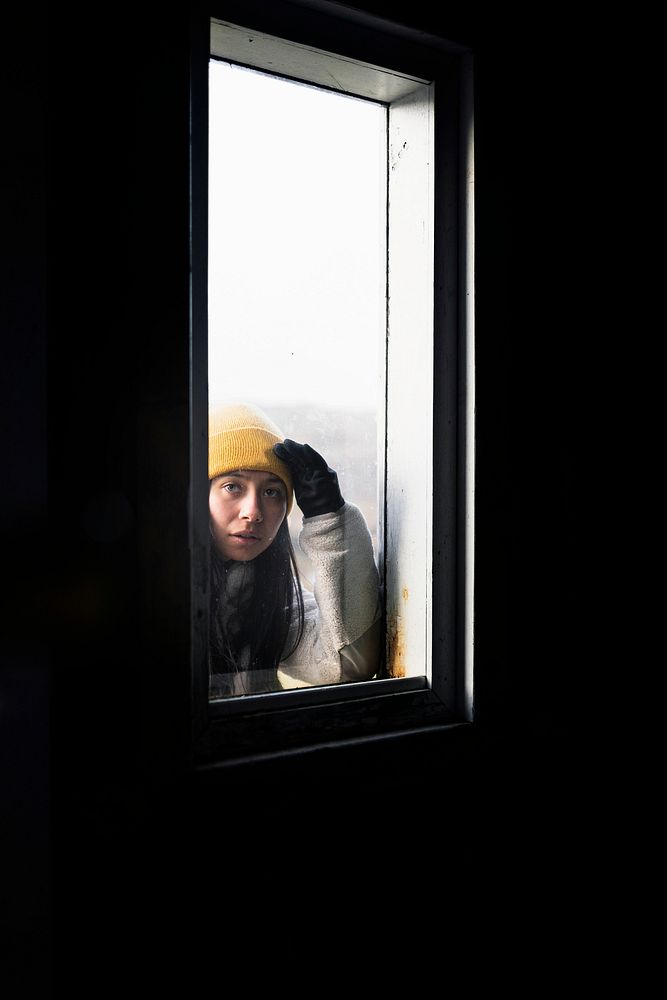 Woman looking through an A-Frame cabin window