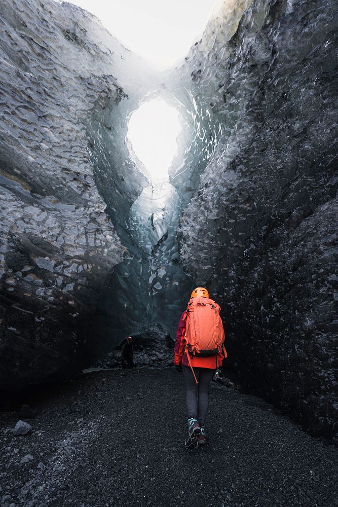 Female explorer walking to the ice cave, Iceland