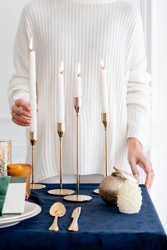 Woman decorating a Christmas dining table with candles