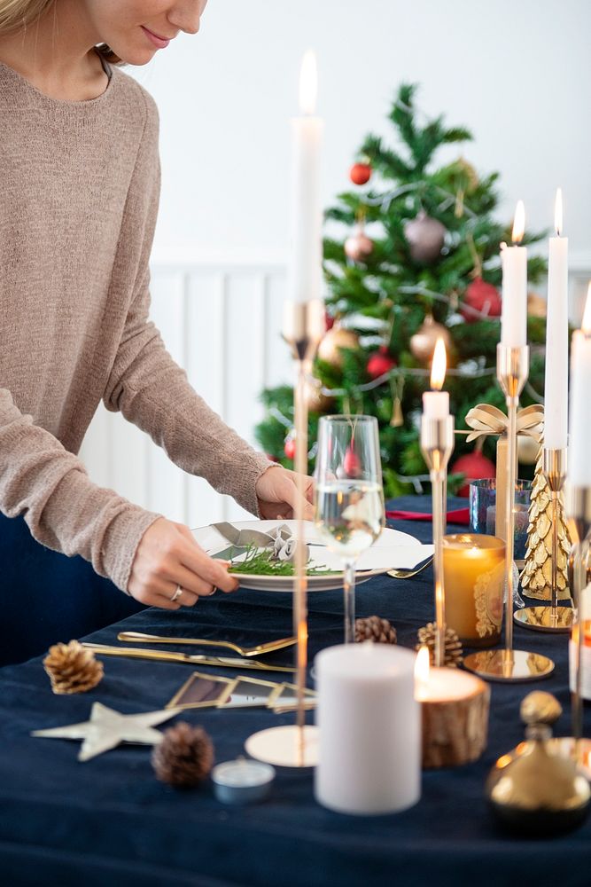 Blond woman setting up a Christmas dining table