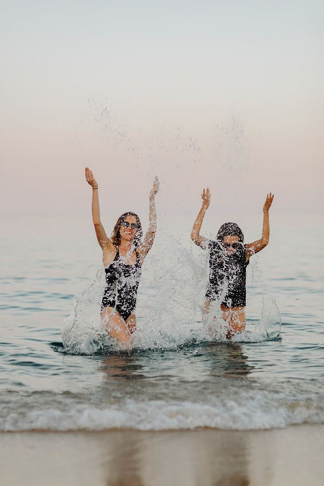 Cheerful girls splashing water at the beach