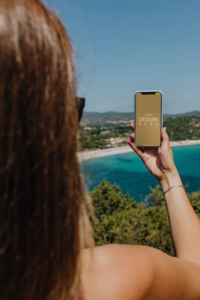 Woman holding a phone at the beach mockup