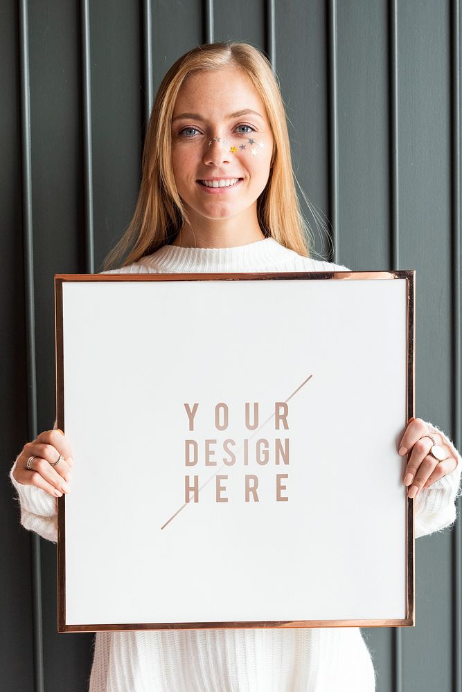 Woman in a white sweater holding a wooden frame mockup