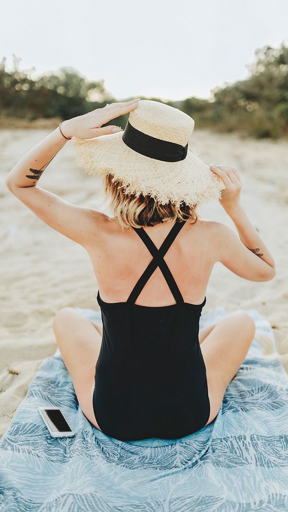 Tanned girl in a black swimsuit at the beach mobile phone wallpaper