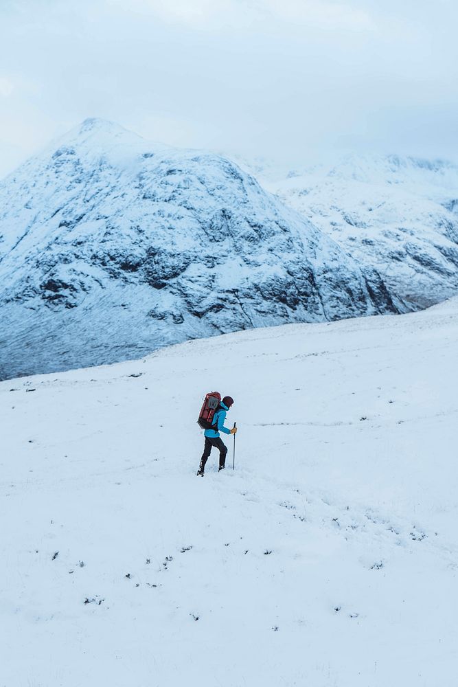 Female mountaineer climbing in wintertime at Glen Coe, Scotland