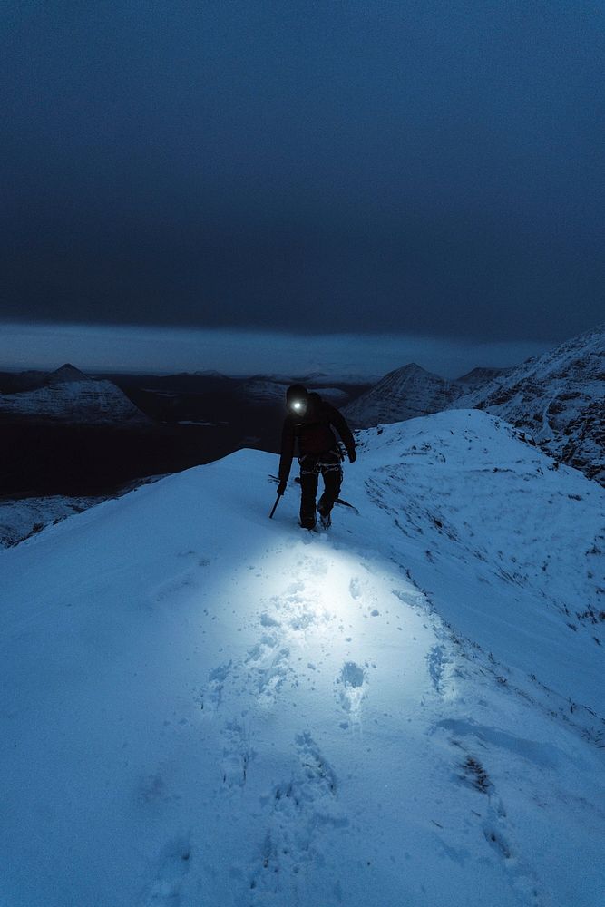 Mountaineer trekking in a cold night at Liathach Ridge, Scotland