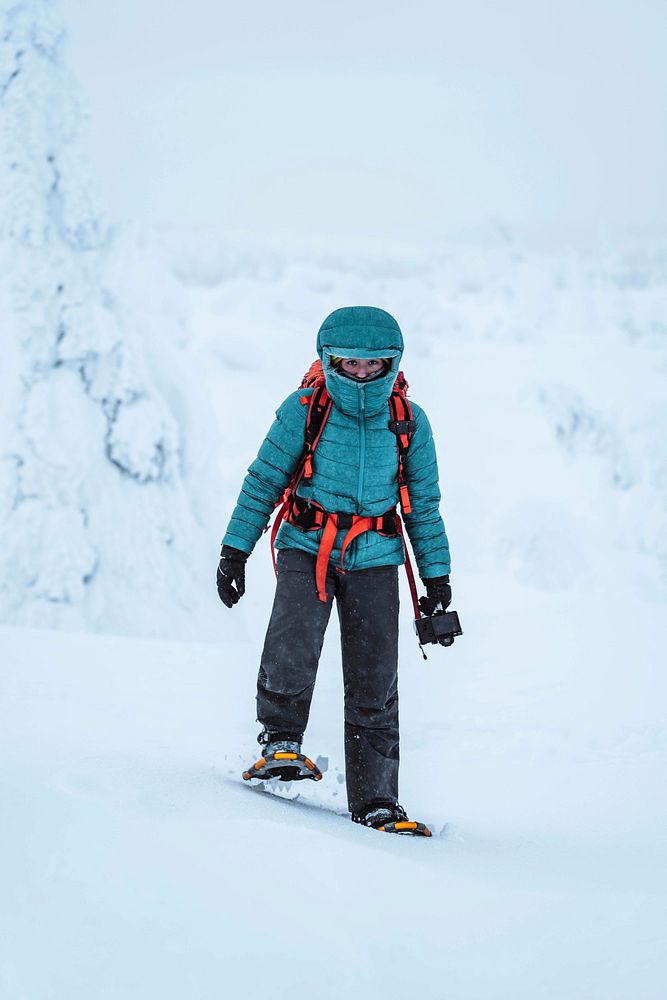 Landscape photographer wearing snowshoes walking in Lapland