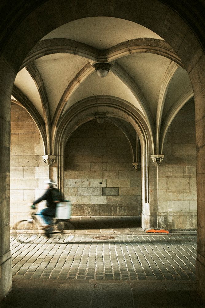 Man riding a bicycle down cobblestone streets