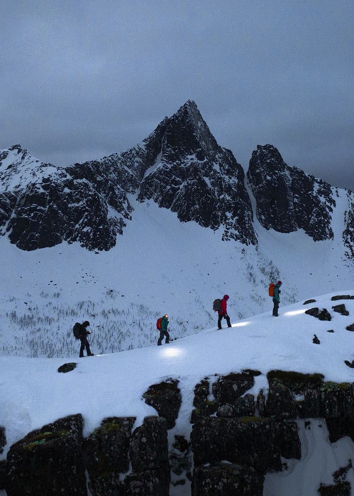 Hikers walking up Segla mountain during the blue hour