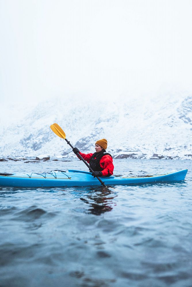 Woman paddling a kayak in Lofoten, Norway