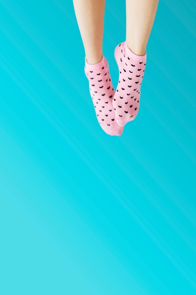 Woman wearing pink socks against a blue background 