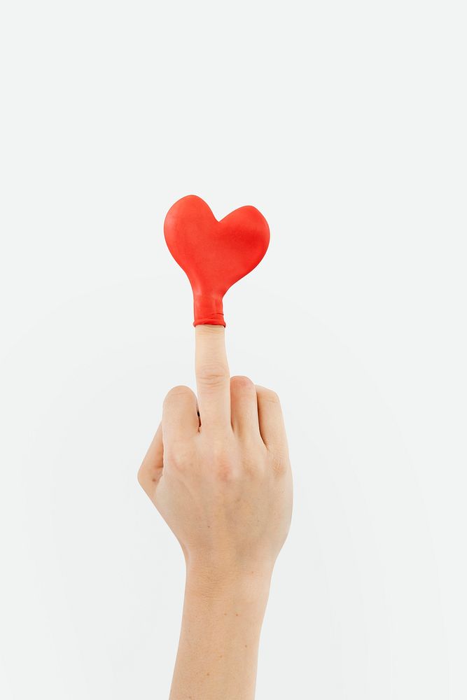 Red heart balloon on a middle finger