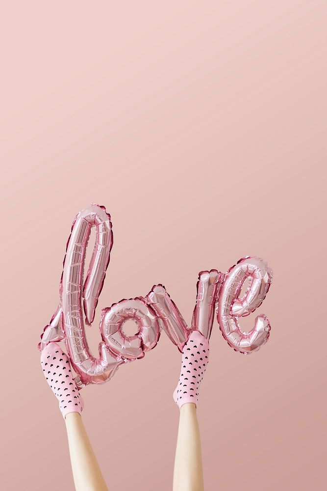 Love glossy pink foil balloon on pink background