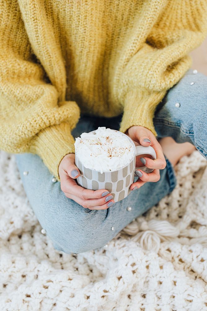 Woman at home drinking hot chocolate with whipped cream 