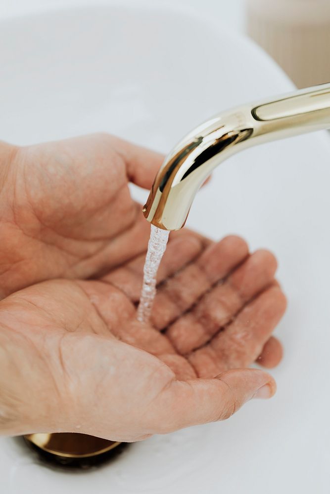 Man washing his hands under a running tap 