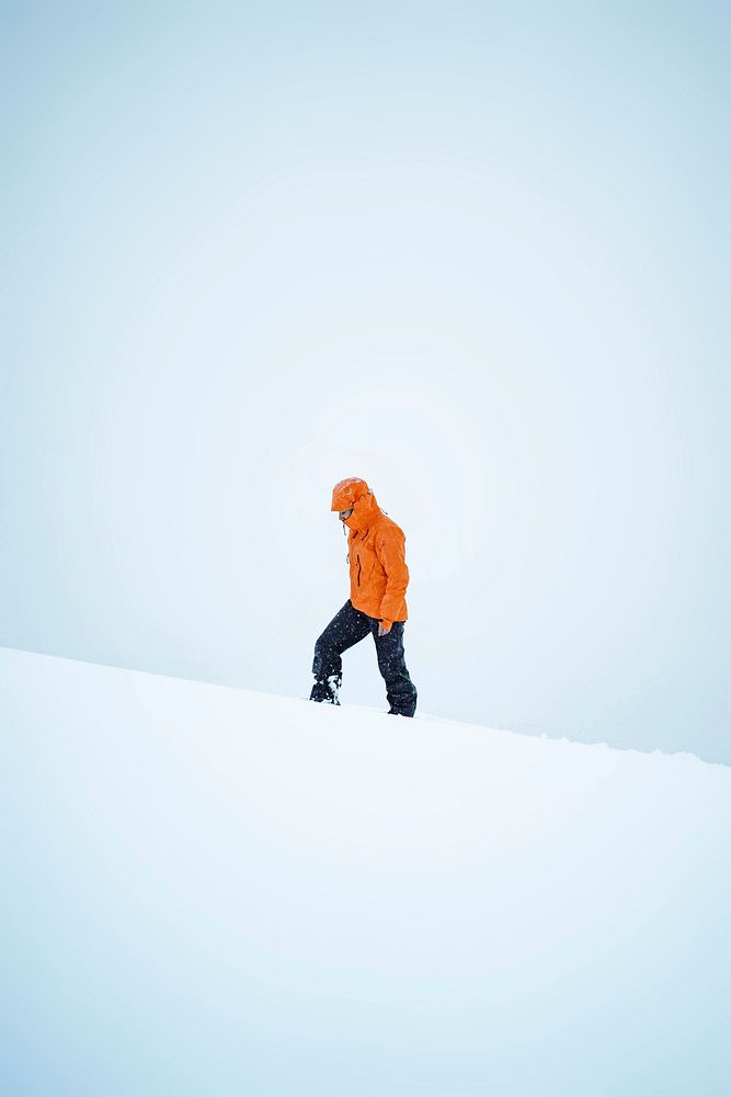 Woman hiking at the snowy mountains in the Faroe Islands
