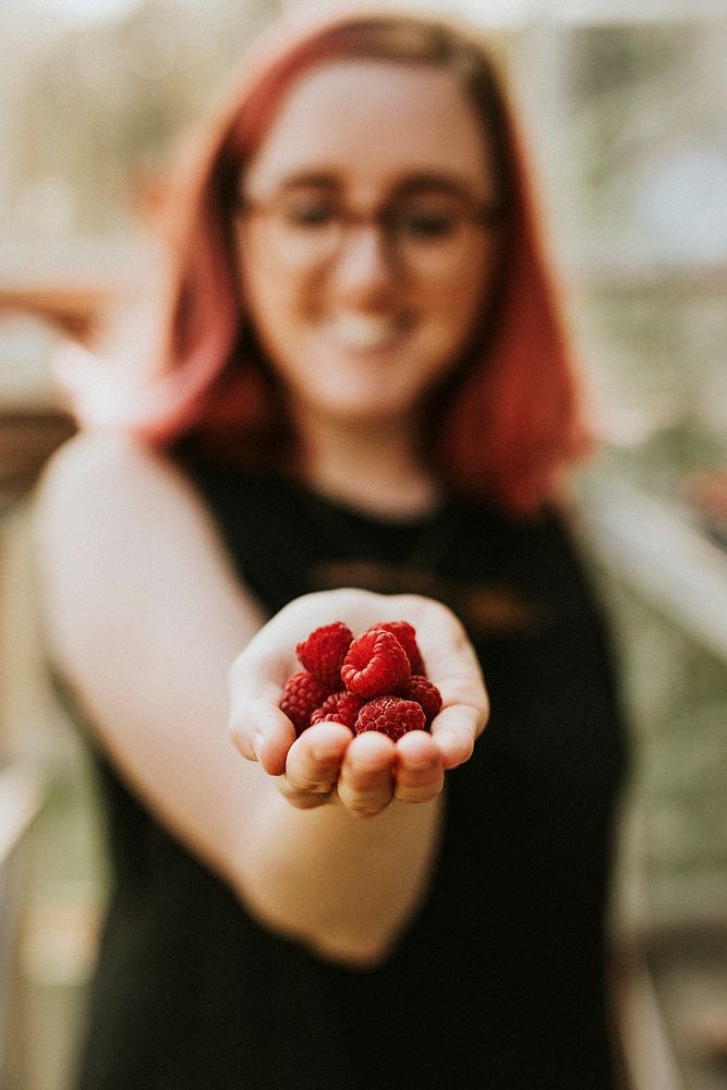 Fresh raspberries on a woman's hand